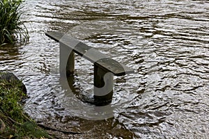 Ã¢â¬ËThe Wet SeatÃ¢â¬â¢ - Riverside Bench Besides the Flooded River Torridge, Torrington, Devon, England. photo